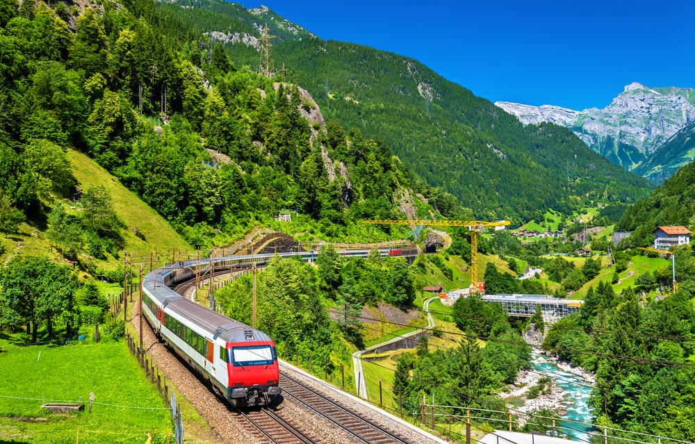 A classic train traveling through scenic European mountains